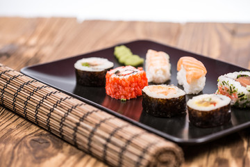 fresh Japanese tasty sushi roll set with chopsticks on wooden ta