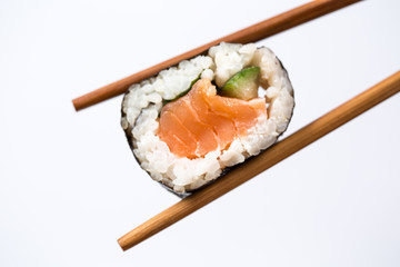 Sushi roll with bamboo chopsticks isolated on white background