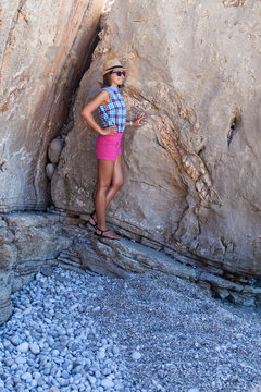 Girl standing at the rock on the shore of the Mediterranean Sea