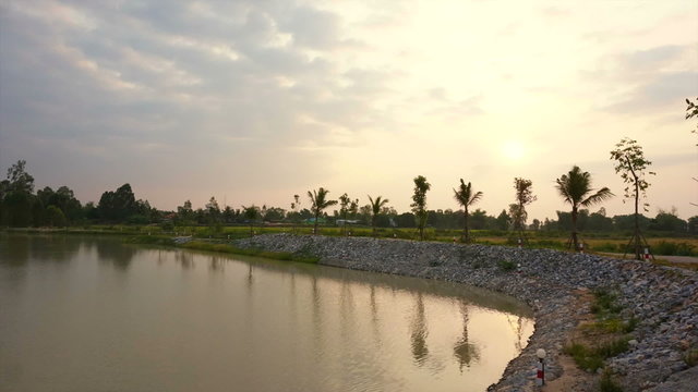 sunrise at lake, man made water reservoir with rice field 