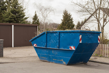 Fototapeta na wymiar Ein grosser blauer Container für den Frühjahrsputz im Garten