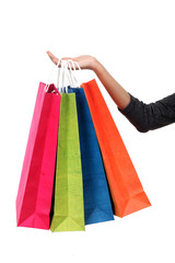 Female hand holding colorful shopping bags against white