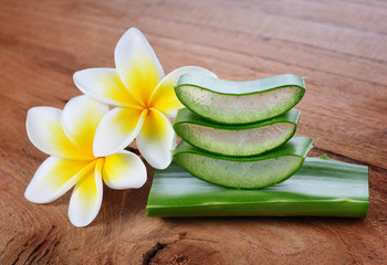 Aloe vera and frangipani flower on wooden