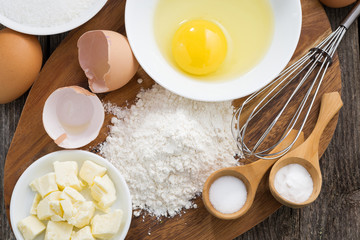 prepared fresh baking ingredients on a wooden board, horizontal