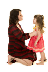pregnant mom kneel and talk to small girl with one shoe on