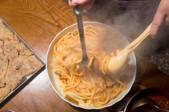 Versamento sugo sulla pasta cotta scolata