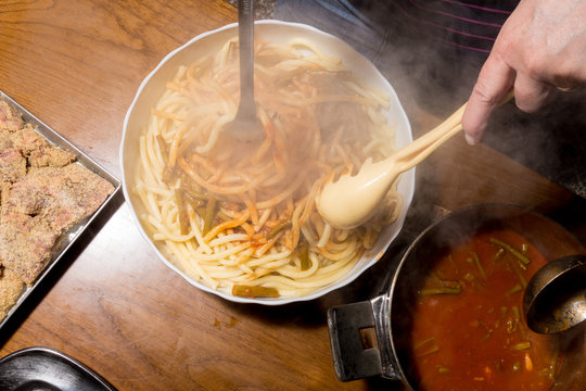 Versamento sugo sulla pasta cotta scolata