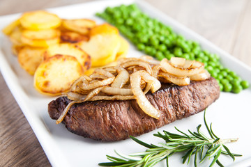 Rinderfilet mit Zwiebeln, Bratkartoffeln und Erbsen