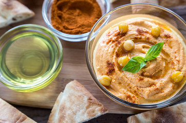 A bowl of hummus with pita slices