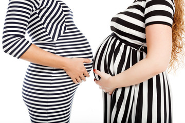 two happy pregnant women is glasses touch their belly - 81683847