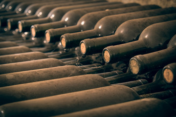 Old wine bottles stacked for aging