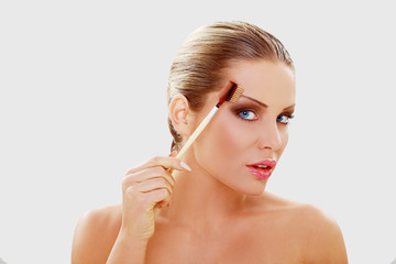 Naklejka premium Beautiful young woman with brushes for make-up