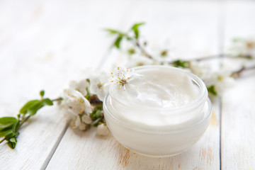 Fototapeta na wymiar Skin cream and beautiful spring white flower