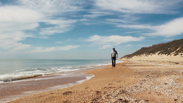 happy man going along the beach enjoing beautiful sea view