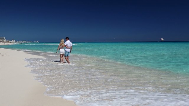 Young couple walking  on caribbean beach