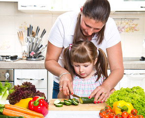 Mother and daughter in kitchen preparing vegetables