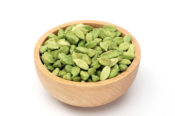 Cardamom pods in a wooden bowl