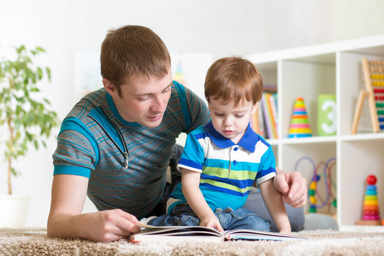 kid boy and his dad read a book