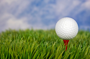 close up of golf ball on red tee in grass
