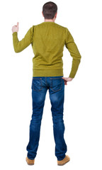 Fototapeta premium Back view of man in blue pullover shows thumbs up.