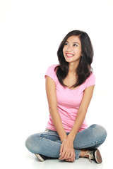 Happy young woman in casual wear sitting and thinking