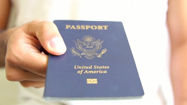 Image of a persons hand holding a passport. travel concept