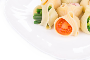 Pasta shells stuffed with vegetables and sausage.