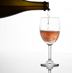 Pouring sparking rose wine on the wine glass