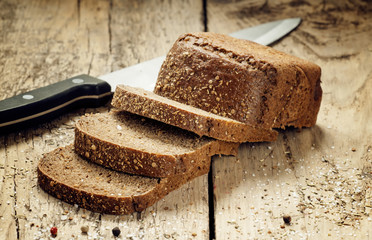 Slices of bread with a knife on a wooden board