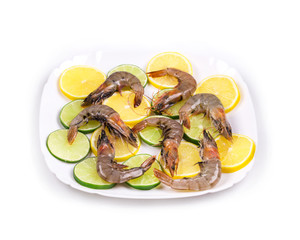 Raw shrimps on plate with lemon.