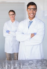 Smiling scientists looking at camera arms crossed