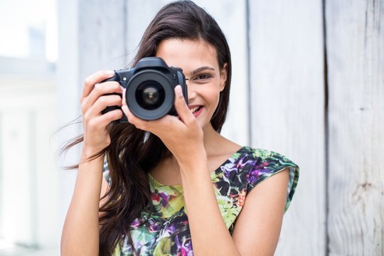 Smiling beautiful brunette taking pictures