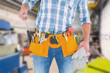 midsection of handyman holding hammer and gloves