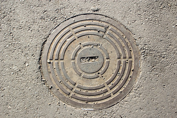 Fototapeta na wymiar Manhole cover on the asphalt surface