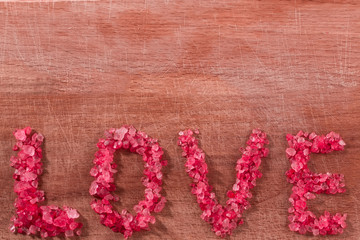 the inscription "love" sea salt on wooden background