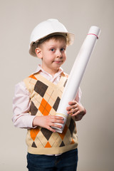 Boy in a construction helmet holding a drawing