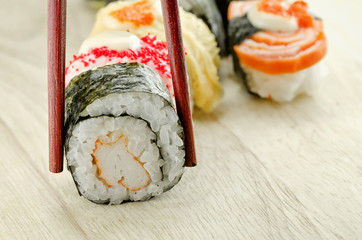 sushi roll in chopsticks