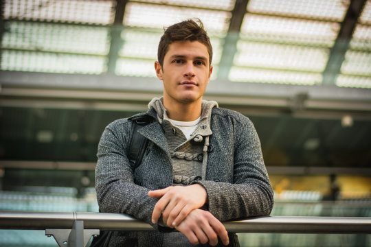 Attractive young man inside modern building, station or airport