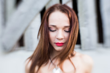 Red-haired young lady with closed eyes
