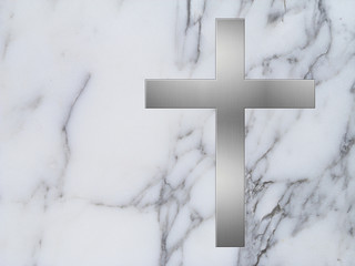 Silbernes Kreuz auf weißem Marmor mit Textfreiraum