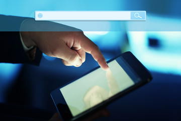 Technology, searching system and internet concept. Male hand touching screen tablet close-up