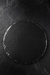 black round slate on black slate background
