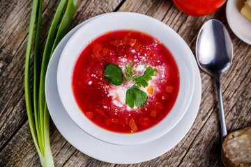 Tasty soup with bread on a wooden background.