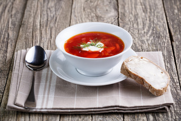Tasty soup with bread on a wooden background.