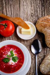 Tasty soup with bread on a wooden background.