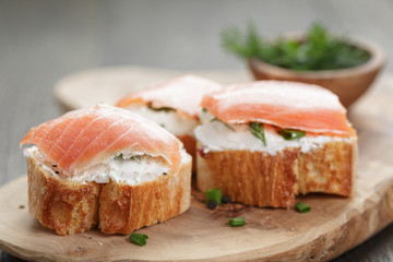 baguette slices with smoked salmon and cheese cream on wooden
