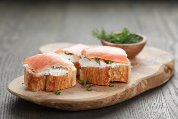 baguette slices with smoked salmon and cheese cream on wooden
