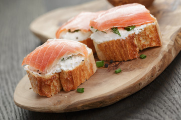 baguette slices with smoked salmon and cheese cream on wooden