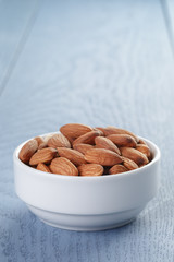 roasted almonds in white bowl on wooden table
