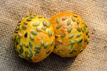 several pumpkin buns with pumpkin seeds on burlap